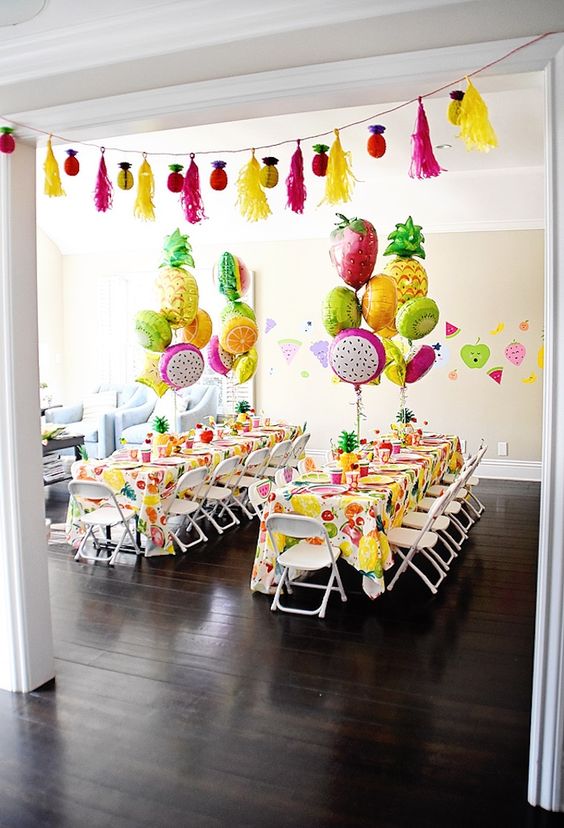 Table centerpieces with flaming pineapple and fruit balloons