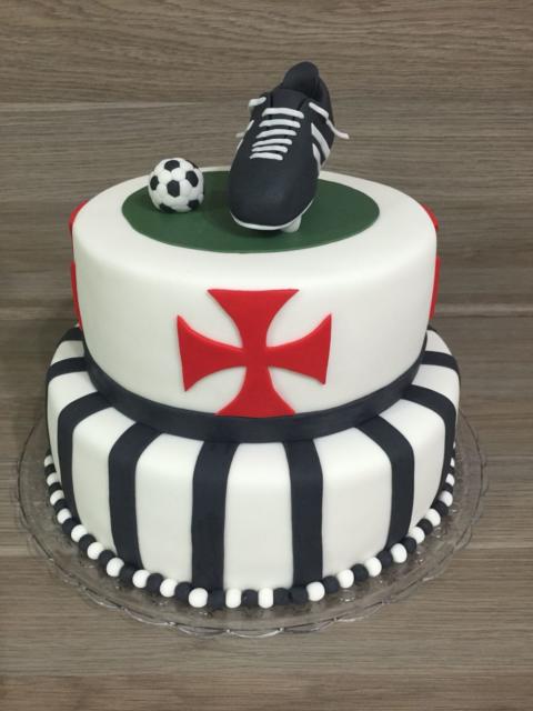 In this two-story cake, we highlight the cross symbol of the club and the football boot 