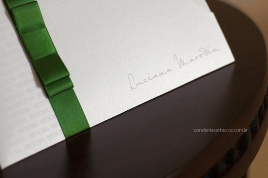 White graduation invitation envelope with green bow