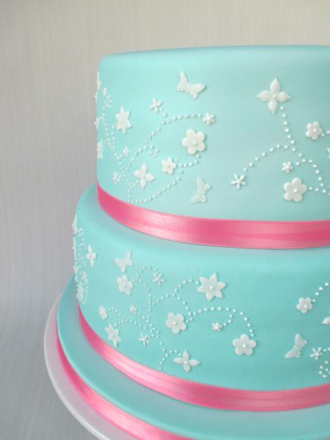 Blue and pink cake with white flowers to decorate