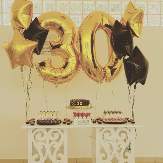Golden number balloons decorated in black and yellow colors