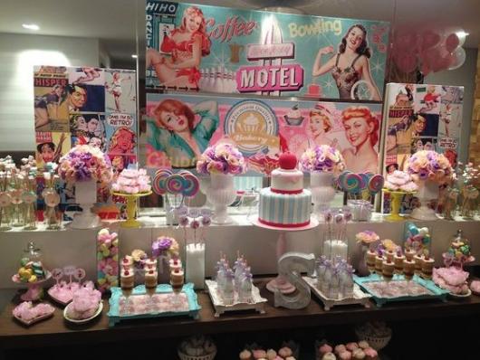 pin-up birthday candy table, with pictures of pin-up women in the background.