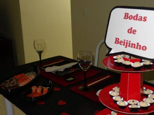 table with Japanese food and kisses on the side with a kissy wedding sign