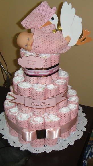 female fake cake with pink polka dot print, bow in the same color and a doll with a stork on top