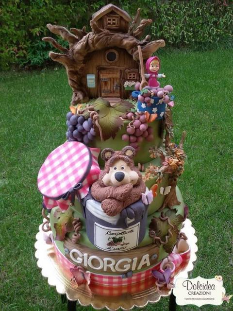 Big cake with the bear inside a pot and the Masha on top.