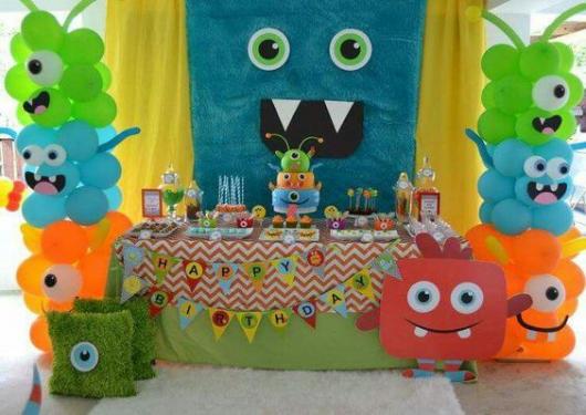 Cake table background with a blue cloth and props imitating a monster.