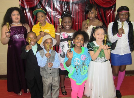 Kids holding golden figurines at Cinema/Hollywood themed party