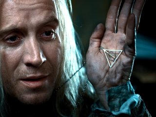 Why does Xenophilius Lovegood wear the Deathly Hallows?